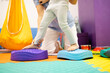 © littlewolf1989 - Pediatric physiatrist supporting a child balancing on sensory stepping stones during a physical therapy session for rehabilitation and developmental coordination