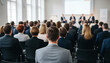 © Riyad - Business people attending a conference or presentation in a modern office setting