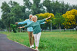 © Lumos sp - Happy active mid aged adult couple having fun walking and balancing and bonding in park or nature outdoors, healhty active mature people exercise concept