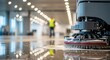 © Gea - Industrial floor cleaning machine in action, cleaning a large commercial space with a person in the background wearing a yellow safety vest