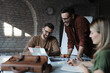 © Novak - Professional business team working together around a large desk in a modern open-space office
