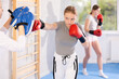 © JackF - Girl strikes at boxing paws. Female athlete works out technique of hitting in tandem with woman teacher and prepares for competition.