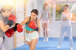 © JackF - Two teen girls in punch mitts boxing in gym