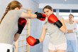 © JackF - Two teen girls in punch mitts boxing in gym