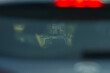 © Viktar - This image showcases a detailed closeup of a rear view mirror found inside a car, prominently featuring a bright red light displayed behind it