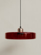 © Yan - Ruby red modern lamp with glossy glass shade and metallic fixture isolated on neutral background