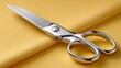 © SashaMagic - High-quality stainless steel scissors on yellow fabric