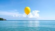 © Rumongso - Yellow balloon floats over tranquil ocean and sky