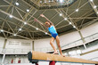 © Natalia Blauth/Stocksy - Gymnast Practicing on Beam Under High Ceiling