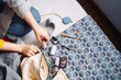 © Maria Sher/Stocksy - Hands working on a sewing project
