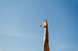 © Felipe Barrera/Stocksy - Hand reaching for the sky on a sunny day