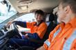 © Rowena Naylor/Stocksy - Workers chatting inside utility vehicle on a sunny day at a site