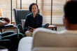 © Jovo Jovanovic/Stocksy - Confident female therapist in armchair discussing with client