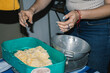 © Laura Herrera/Stocksy - Woman picking up mashed corn from grinding machine