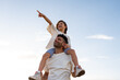 © Stephanie Tamir/Stocksy - A dad lifts his daughter onto his shoulders, both laughing.