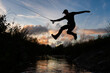 © Jonas Høholt/Stocksy - Man leaps over creek with fishing rod in hand