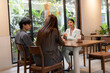 © Jestercine - Female business advisor discussing strategy with male and female cafe owners in a modern restaurant interior. Concept of partnership, SME consulting, and professional interaction.