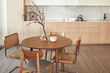 © Amor Burakova/Stocksy - Modern kitchen interior featuring a round wooden table with chairs