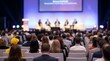 © CuteBee - An engaged audience, viewed from the back, intently watches a panel discussion on a brightly lit stage at a business conference.