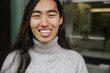 © Rob and Julia Campbell/Stocksy - Portrait of a Smiling Individual in Cozy Winter Attire Outdoors