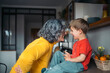 © Santi Nuñez/Stocksy - Grandmother and grandson sharing a loving moment in the kitchen