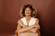 © Tania Cervian/Stocksy - Young woman with curly hair hugging herself and smiling