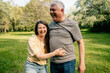 © Maria Sher/Stocksy - Two people laughing together in sunny green park