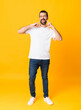 © luismolinero - Full-length shot of man with beard over isolated yellow background smiling with a happy and pleasant expression