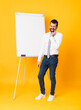 © luismolinero - Full-length shot of businessman giving a presentation on white board over isolated yellow background with toothache