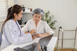 © Rakchanok - Senior, doctor, healthcare, elderly, medical patient consultation at clinic with laptop and tablet diagnosis talk, symptom assessment, chart review, monitoring results, follow up, Senior healthcare