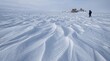 © flashmovie - Person with backpack trekking across a remote, wind-sculpted arctic snowfield, conveying solitude, resilience and quiet exploration in a vast, frozen wilderness
