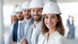 © Nataliya - Faceless smiling team of professional architects and engineers in hardhats at construction site meeting, project collaboration, defocused background, with copy space
