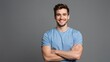 © Studicon - Smiling young man with crossed arms looks straight ahead at the viewer