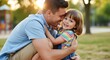 © Bani - Father hugs his happy daughter outdoors with soft golden light.
