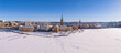 © John N - Wintry Stockholm old town, with ice and snow, and people walking on the lake, clear blue sky, Riddarholmen church, panoramic aerial view