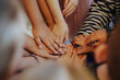© Alice - A group of teenagers holding hands, demonstrating unity and teamwork before the start of the game. Friends in nature with collaboration, community, or teaming up to create a team.