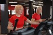 © New Africa - Senior couple training on elliptical machines in gym