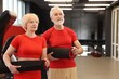 © New Africa - Senior couple with fitness mats in gym, space for text