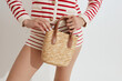 © Serge Filimonov/Stocksy - Anonymous woman holding summer straw bag