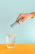 © Tatyana Lavrova/Stocksy - A hand dissolving a sachet with powder supplements in a glass of water