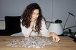 © Aleksei Toropov/Stocksy - A young woman is putting together a puzzle