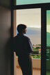© Eliza Alves/Stocksy - Man looking at the sea in a balcony at sunset