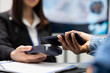 © DC Studio - Patient using smartphone for cashless medical payment as clinic receptionist processes transaction with card reader. Black individual pays hospital fees, tapping mobile device on pos machine.