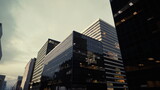 moody glass skyscrapers at dusk, reflective facades and sharp angles on modern corporate towers cinematic atmosphere with brooding sky, mirror windows,