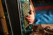 © Natalia Mishina/Stocksy - Musician playing accordion with vibrant background at home