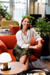 © Artem Podrez/Stocksy - Portrait Smiling Woman Sitting in Office Lounge