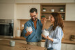 © Miljan Živković - Happy couple achieving financial goals with piggy banks