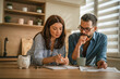 © Miljan Živković - Couple managing home finances, budgeting expenses, and planning savings
