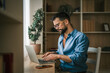 © Miljan Živković - Man working from home on laptop, telecommuting smiling