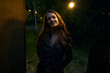 © Ivan Jovanovic/Stocksy - Smiling woman stands alone in the night